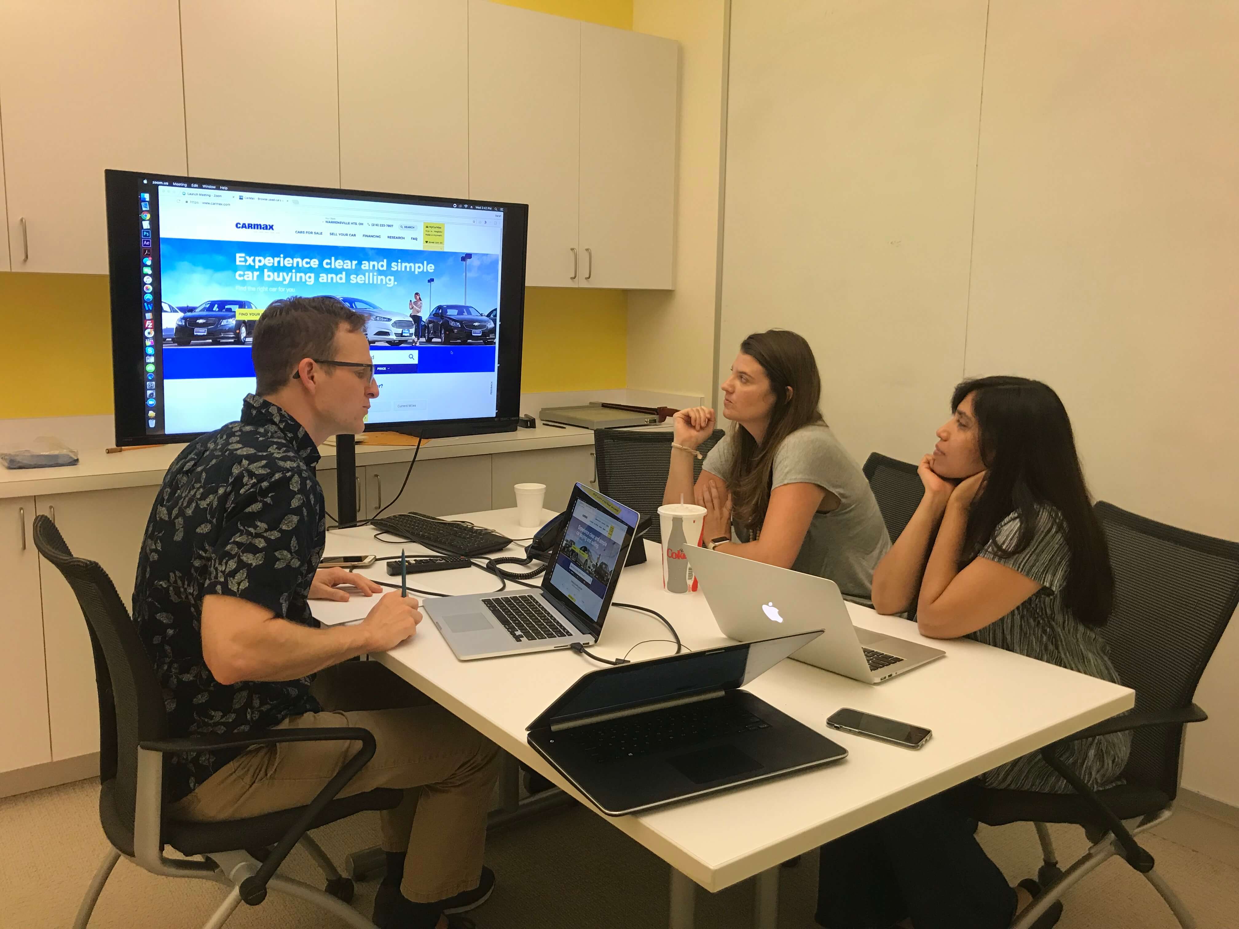 The product team gathered around a table looking at a monitor