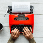 A person typing on a typewriter.