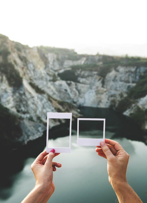 Two hands holding up two different shaped frames