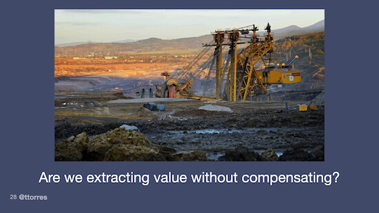 A photograph of an oil drilling rig. The caption on the image reads, "Are we extracting value without compensating?"