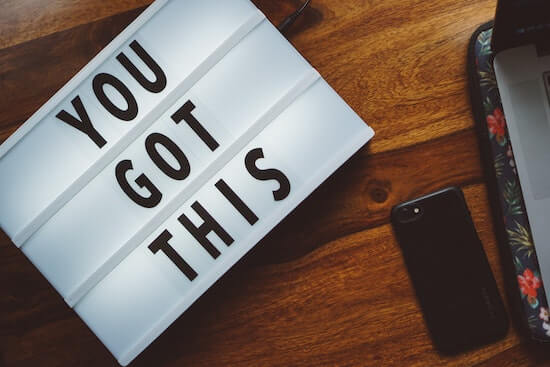 A photo of a desk with a sign that reads "You got this" on it.