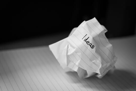 A photograph of a crumpled up piece of paper with the word "ideas" written on it.