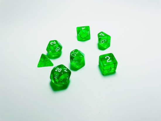 A photograph of several differently shaped dice on a white tabletop.