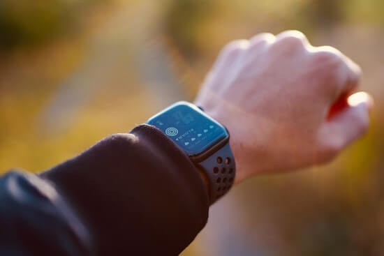 A photograph of a person's wrist with a smart watch showing their physical activity.