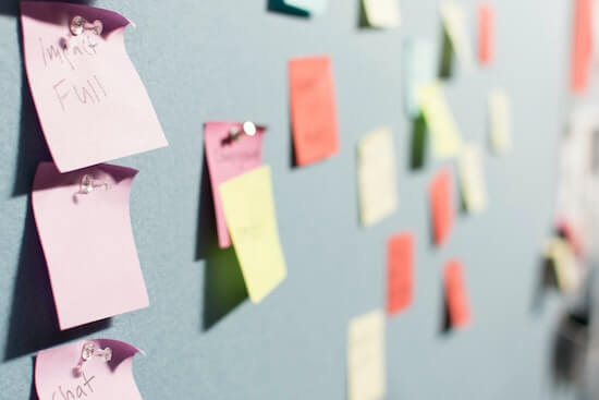 A photograph of a whiteboard covered in colorful sticky notes.